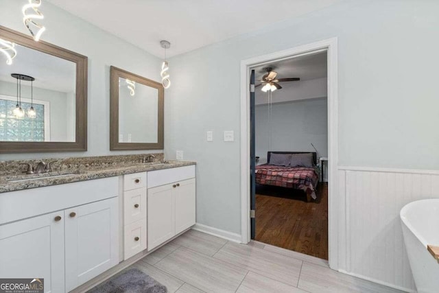 bathroom with a tub, vanity, ceiling fan, and hardwood / wood-style flooring