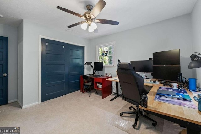 carpeted home office featuring ceiling fan