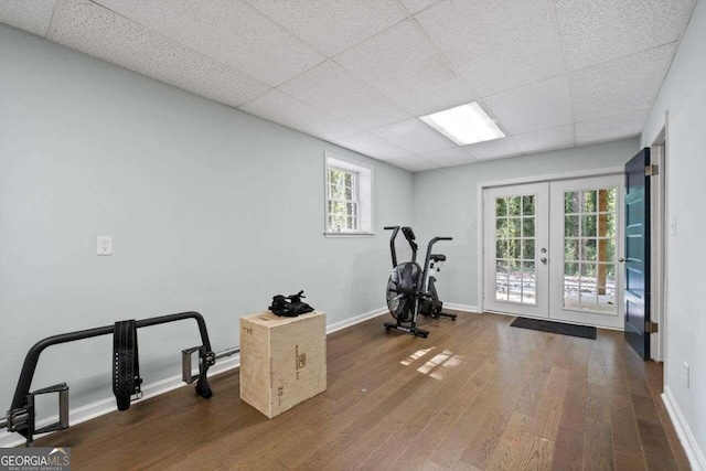 exercise area with french doors, dark hardwood / wood-style floors, and a paneled ceiling