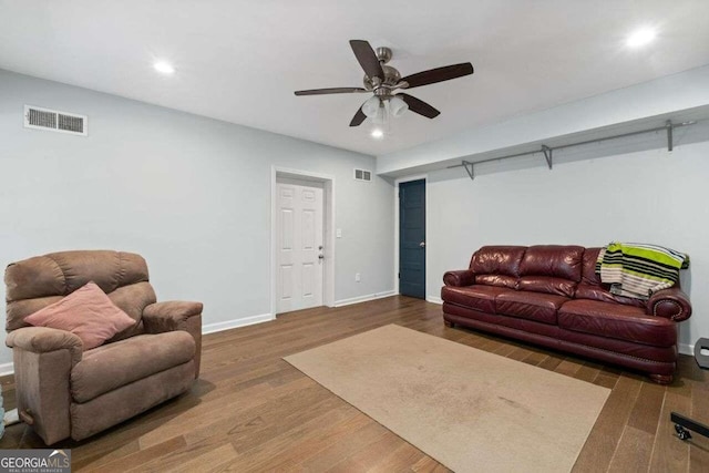 living room featuring ceiling fan and dark wood-type flooring