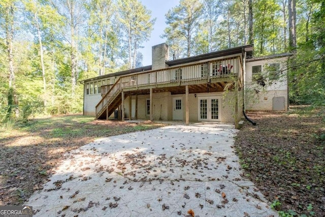 back of house featuring a patio, a wooden deck, and french doors