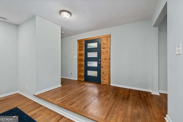 foyer with a textured ceiling and hardwood / wood-style flooring