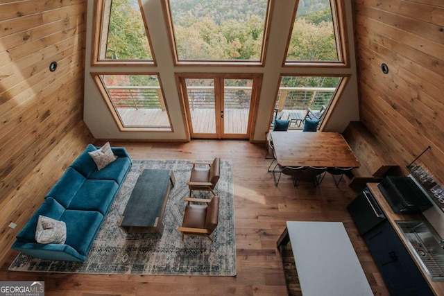 living room featuring hardwood / wood-style flooring, wooden walls, and a wealth of natural light