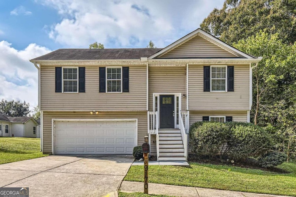 split foyer home featuring a front lawn and a garage