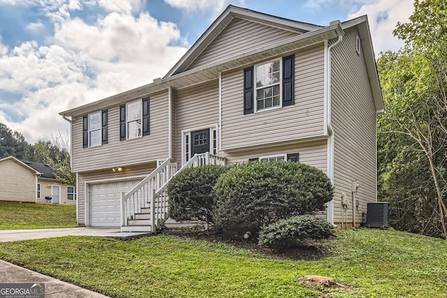 bi-level home featuring central air condition unit, a front yard, and a garage