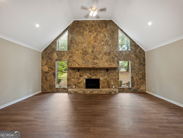 unfurnished living room featuring ceiling fan, dark wood-type flooring, a stone fireplace, ornamental molding, and high vaulted ceiling