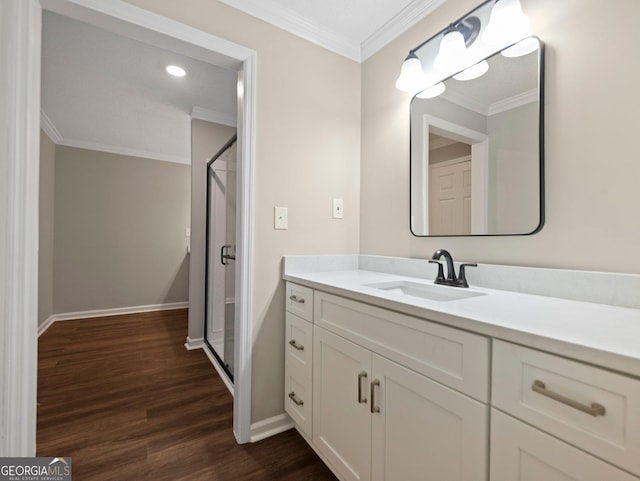 bathroom featuring ornamental molding, walk in shower, hardwood / wood-style flooring, and vanity