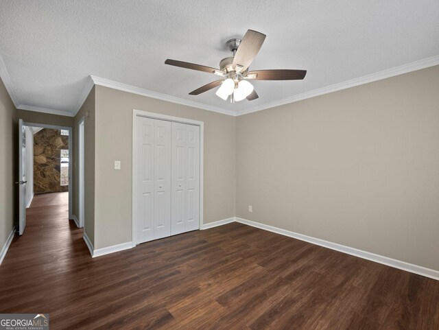 unfurnished bedroom featuring a textured ceiling, dark hardwood / wood-style floors, a closet, ornamental molding, and ceiling fan