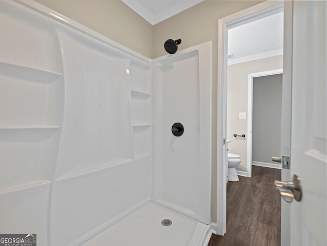 bathroom featuring wood-type flooring, toilet, walk in shower, and crown molding