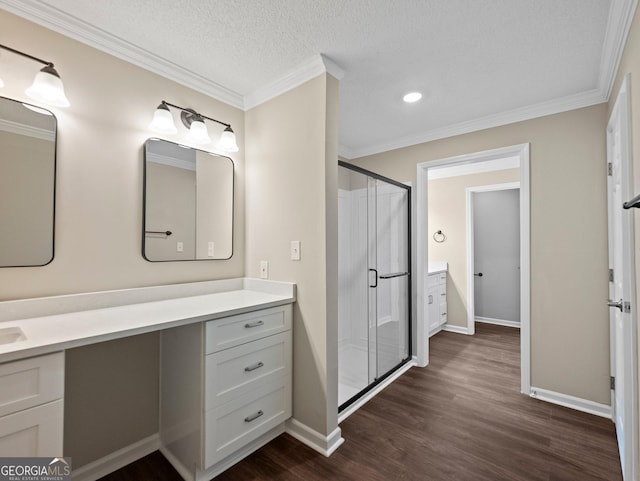 bathroom featuring wood-type flooring, walk in shower, ornamental molding, and vanity