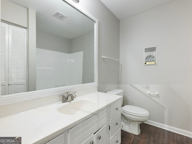 bathroom with hardwood / wood-style flooring, toilet, and vanity