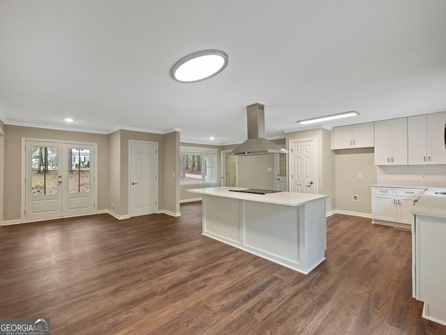 kitchen featuring white cabinetry, island range hood, black electric stovetop, dark hardwood / wood-style floors, and a center island