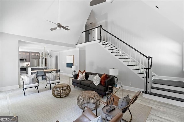 living room featuring ceiling fan with notable chandelier, high vaulted ceiling, and light hardwood / wood-style floors