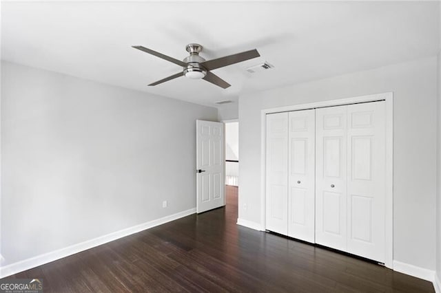 unfurnished bedroom with a closet, dark hardwood / wood-style flooring, and ceiling fan