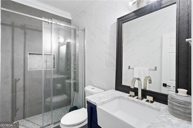 bathroom with vanity, a shower with shower door, tile walls, crown molding, and toilet