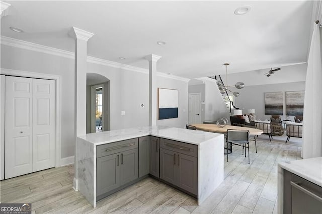 kitchen featuring ornate columns, light hardwood / wood-style floors, crown molding, and gray cabinetry