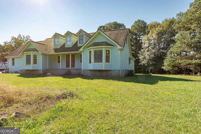 view of front of house with a front yard and central AC unit