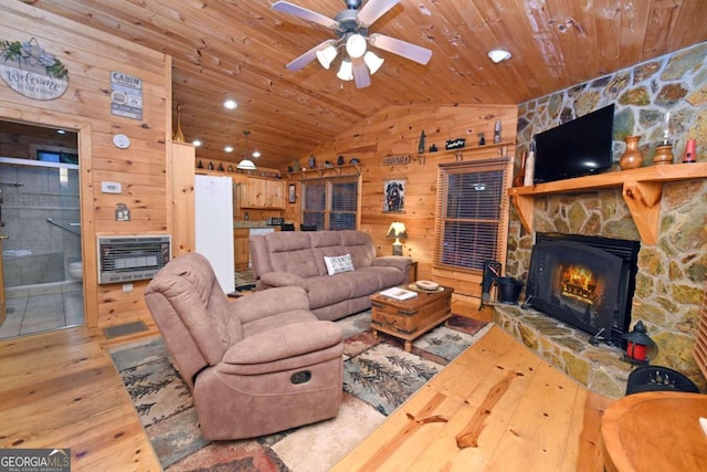 living room with lofted ceiling, light wood-type flooring, a stone fireplace, wooden ceiling, and wood walls