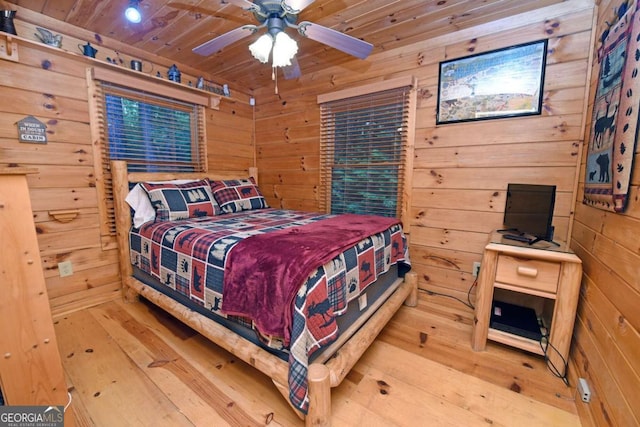 bedroom featuring wood-type flooring, wood walls, wooden ceiling, and ceiling fan