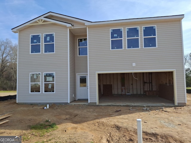 rear view of house featuring a garage