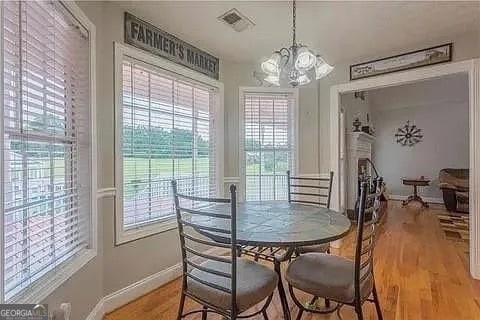 dining space featuring a notable chandelier, light wood-type flooring, and a wealth of natural light