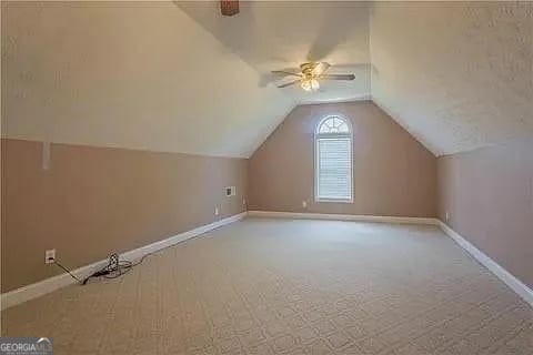 bonus room with lofted ceiling, carpet floors, and ceiling fan