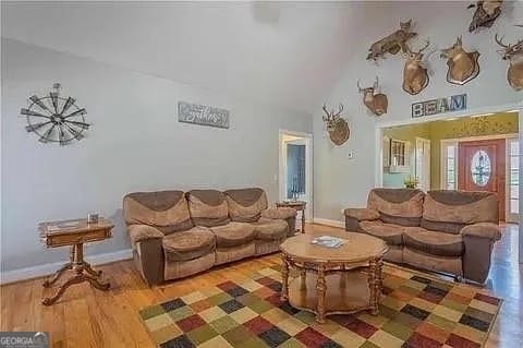 living room featuring hardwood / wood-style flooring and vaulted ceiling