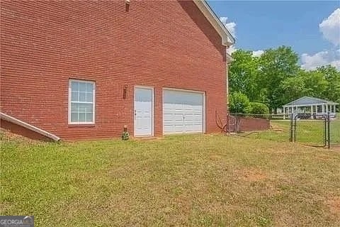 back of house featuring a yard and a garage