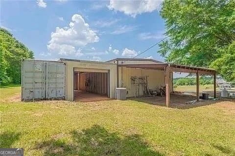 view of outbuilding featuring central air condition unit and a yard