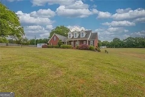 cape cod home featuring a front lawn