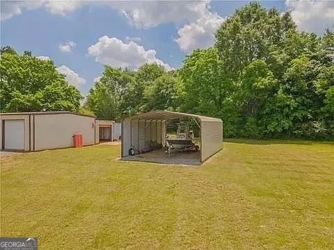 view of yard with an outbuilding and a carport