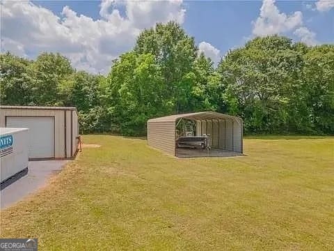 view of yard featuring a carport and an outdoor structure