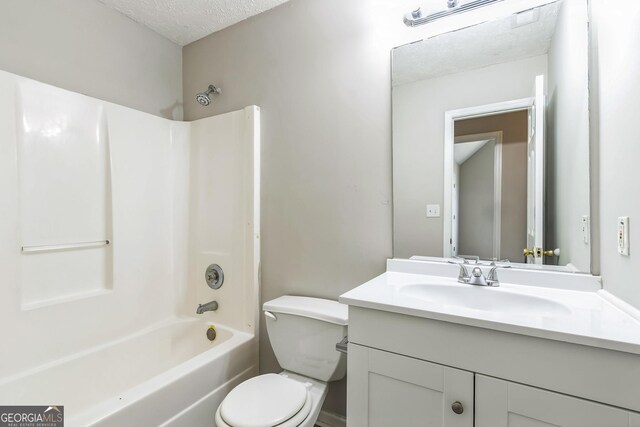 full bath with a textured ceiling, shower / bath combination, vanity, and toilet