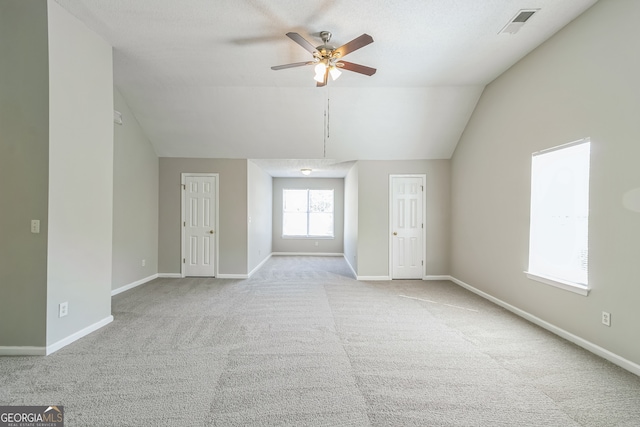 carpeted empty room with lofted ceiling and ceiling fan