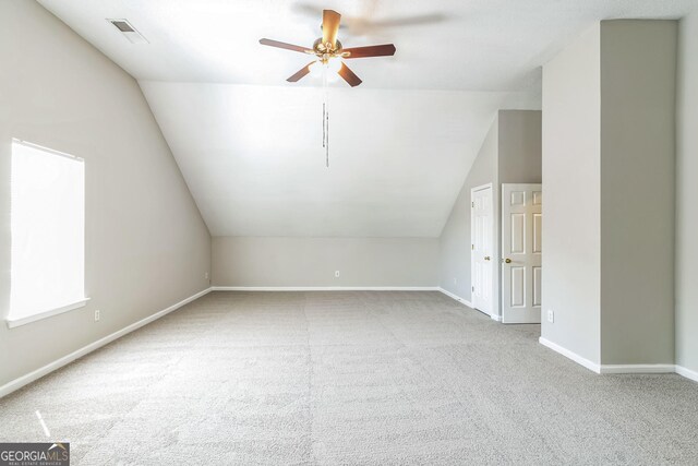 bonus room featuring carpet flooring, vaulted ceiling, visible vents, baseboards, and a ceiling fan