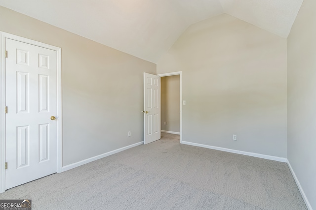 unfurnished bedroom with lofted ceiling and light carpet