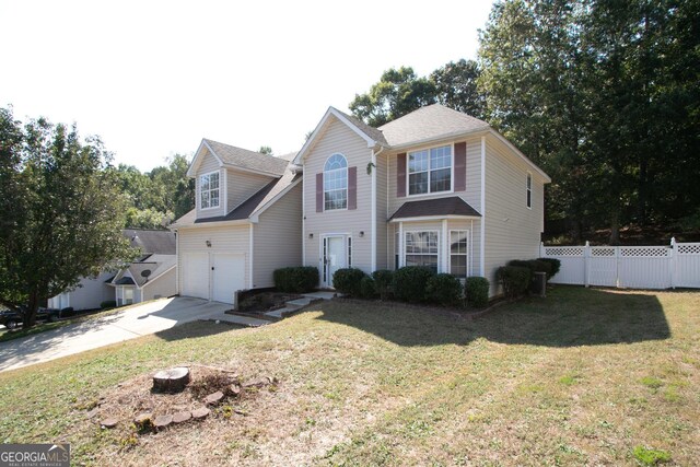 traditional home with an attached garage, driveway, a front lawn, and fence