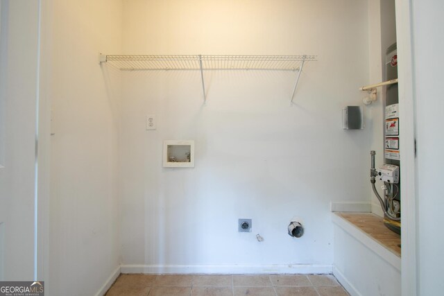 clothes washing area featuring laundry area, light tile patterned floors, hookup for an electric dryer, gas dryer hookup, and hookup for a washing machine