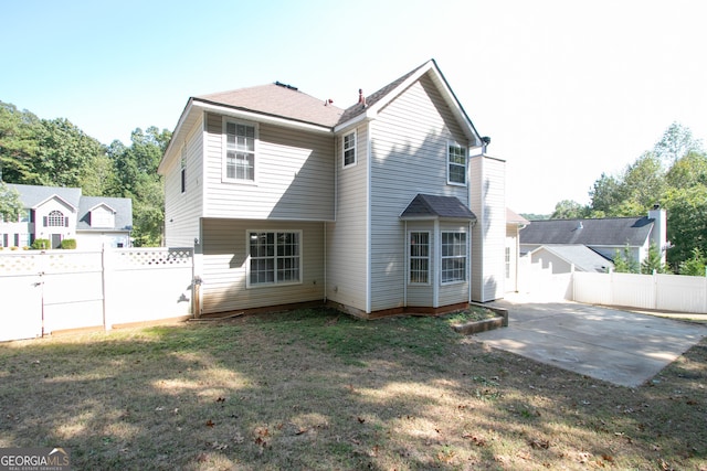 rear view of house featuring a yard and a patio area