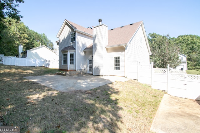 rear view of property with a yard and a patio area