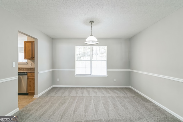 carpeted empty room with a textured ceiling