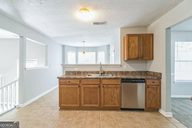 kitchen with light tile patterned flooring, hanging light fixtures, sink, and stainless steel dishwasher