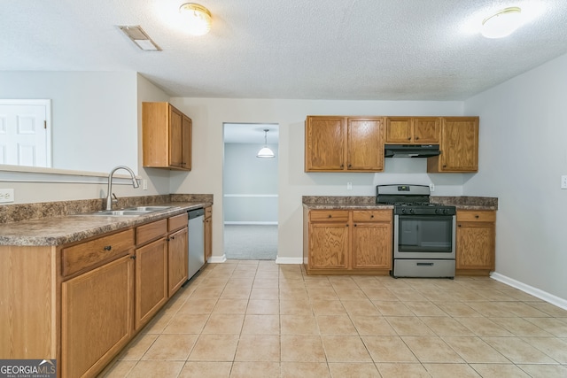 kitchen featuring stainless steel appliances, sink, light tile patterned floors, and a textured ceiling