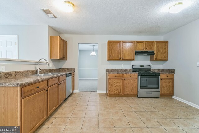 kitchen with under cabinet range hood, stainless steel appliances, visible vents, a sink, and baseboards