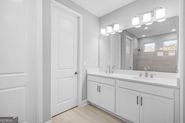 bathroom with hardwood / wood-style floors, vanity, and walk in shower