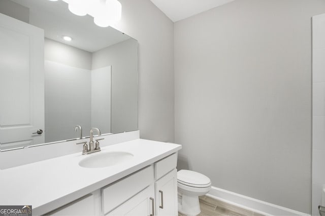 bathroom with toilet, vanity, walk in shower, and wood-type flooring