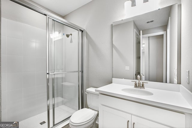 bathroom with toilet, vanity, and an enclosed shower