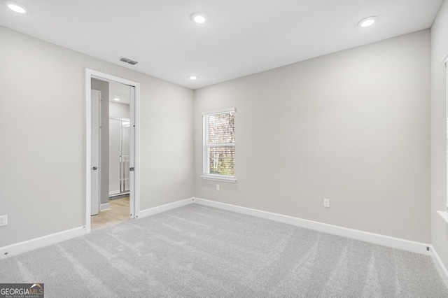 interior space with light carpet and connected bathroom