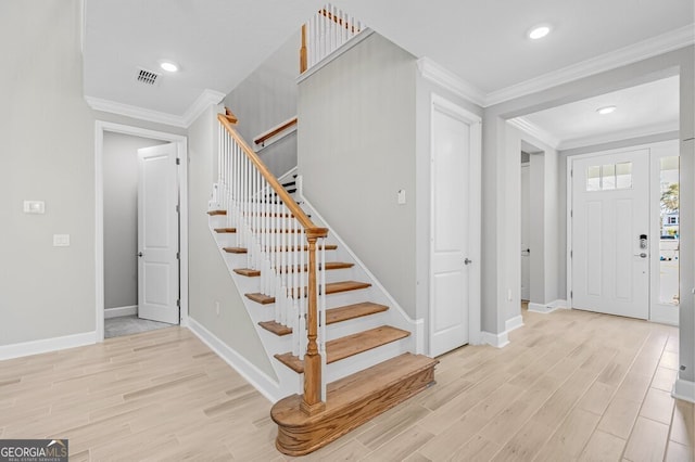 foyer entrance featuring light wood-type flooring and ornamental molding