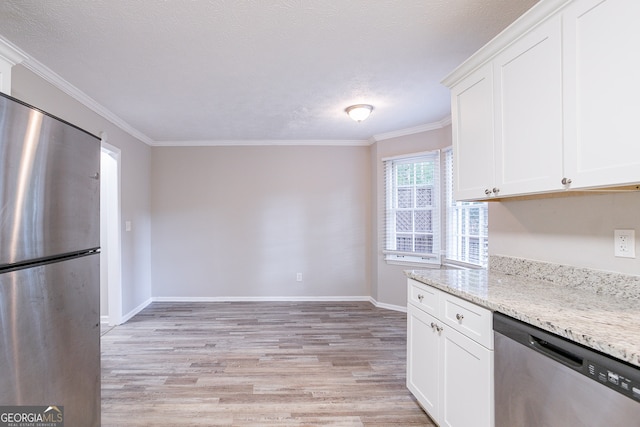 kitchen featuring light wood-type flooring, light stone countertops, ornamental molding, white cabinetry, and appliances with stainless steel finishes